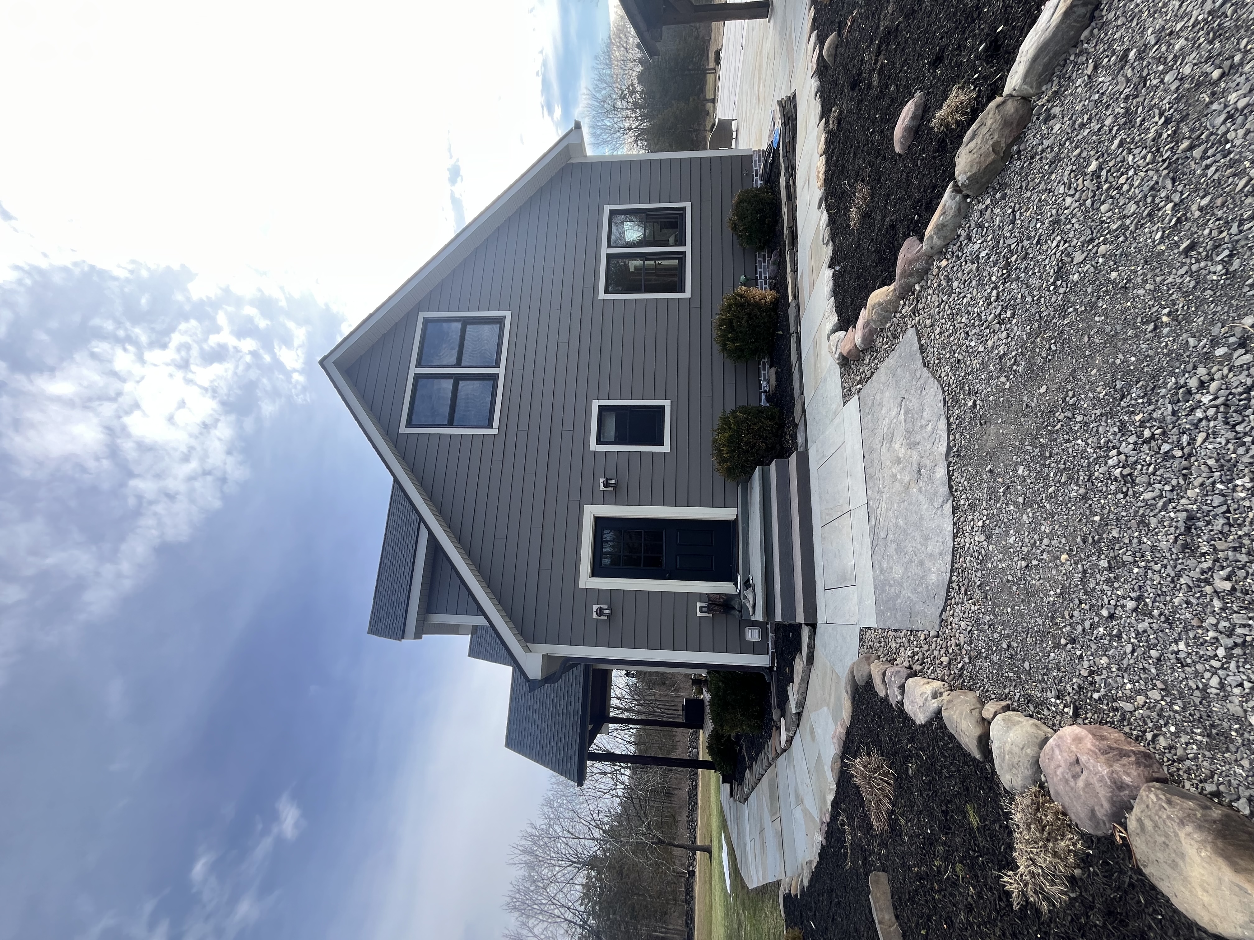 Gray fiber cement siding shingle roof home by Fibinachi Construction