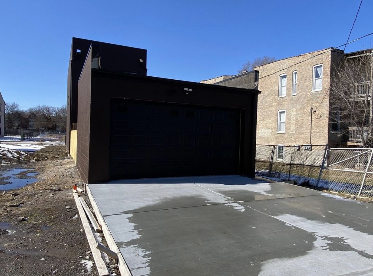 New construction with concrete driveway by Fibinachi Construction