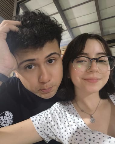 Brandon tocandose el pelo y Katheryn sonriendo a su lado