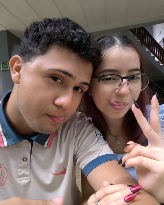 Katheryn y Brandon muy juntos, sacando la lengua a la camara y con las manos entrelazadas