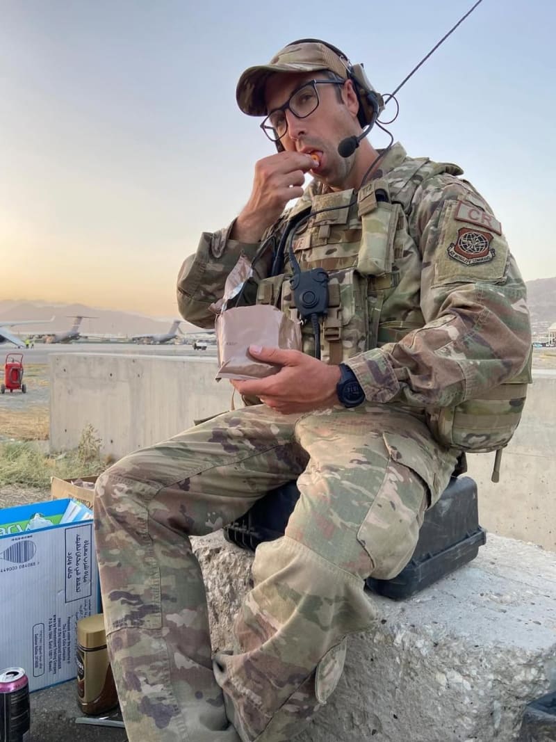 Chris Maye in Air Force field uniform during a deployment, seated with a headset.