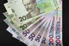 Fanned out Ukrainian Hryvnia banknotes featuring various denominations and vivid colors.