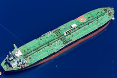 Aerial shot of an oil tanker sailing in the ocean near Vado Ligure, Italy.