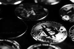 Monochrome close-up shot of Bitcoin and cryptocurrency coins, capturing digital currency essence.