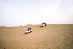 4x4 vehicles navigate rolling desert dunes during a thrilling offroad adventure.