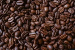 Closeup of aromatic roasted coffee beans showcasing rich textures and deep brown hues.