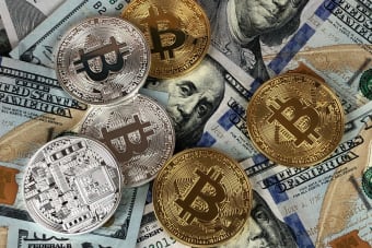 Close-up of bitcoins and US dollar bills symbolizing modern finance and cryptocurrency.