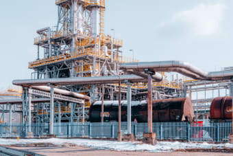 Oil refinery facility with tanker wagons in Trzebinia, Lesser Poland Voivodeship under a clear sky.