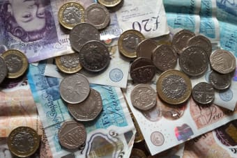 Close-up of British coins and banknotes, showcasing different denominations for financial concepts.