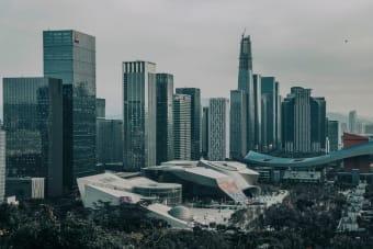 A modern urban skyline featuring numerous skyscrapers under a gloomy sky.
