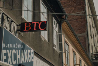 Exterior of a building featuring a prominent BTC and exchange sign, indicating a cryptocurrency location.