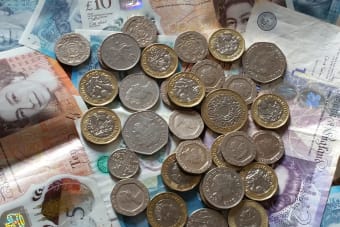 A detailed image of British Pound Sterling coins and banknotes, perfect for finance-related projects.