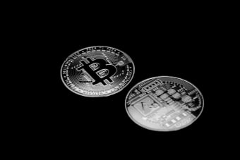 Silver Bitcoin coins displayed on a sleek black background, symbolizing modern digital currency.