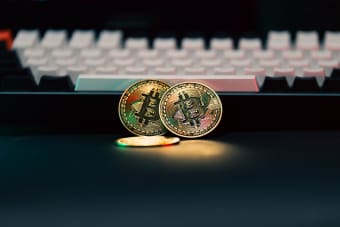 Golden Bitcoin coins in front of a keyboard, symbolizing digital currency and finance