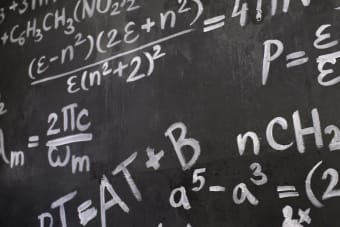 Close-up view of a blackboard filled with complex mathematical equations and formulas.