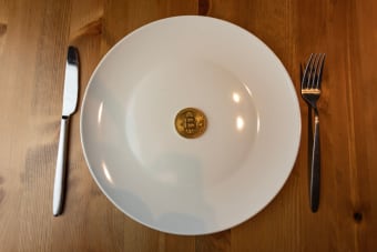 A conceptual image of a bitcoin placed on a dinner plate symbolizing the digital economy.
