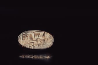 Detailed close-up of a digital cryptocurrency coin reflecting light on a sleek black background.