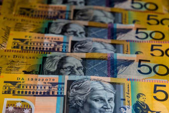 Close-up view of Australian $50 bills arranged in a pattern. Vibrant colors and detailed imagery highlight currency features.
