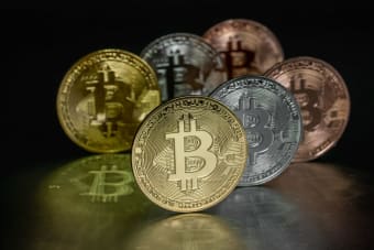 Close-up image of Bitcoin coins displayed on a reflective metallic surface, highlighting cryptocurrency concepts.
