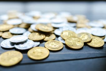 A detailed view of various cryptocurrency coins scattered on a wooden surface.
