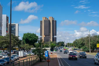Street view in Brasilia featuring the Central Bank of Brazil under a vibrant sky.