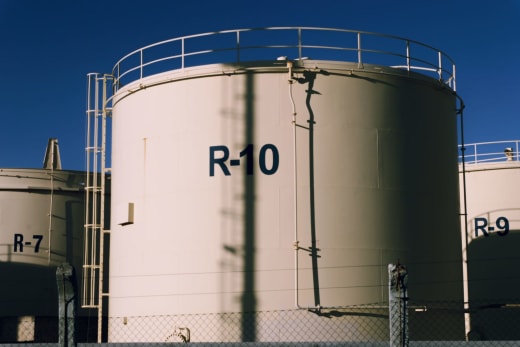 Large industrial storage tanks under blue skies, highlighting metal structures.