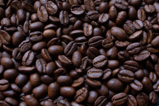 A detailed view of dark roasted coffee beans, ideal for rich and aromatic coffee brews.