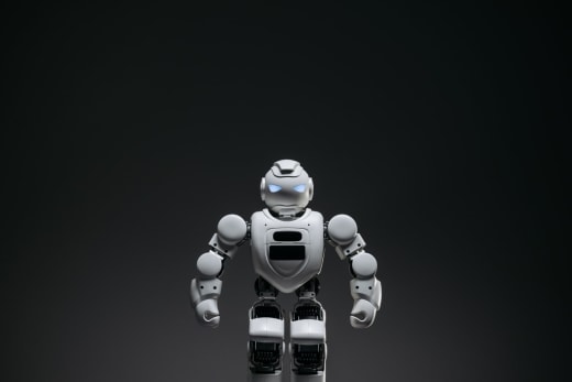 Close-up of a white toy robot with glowing eyes in a studio setting.
