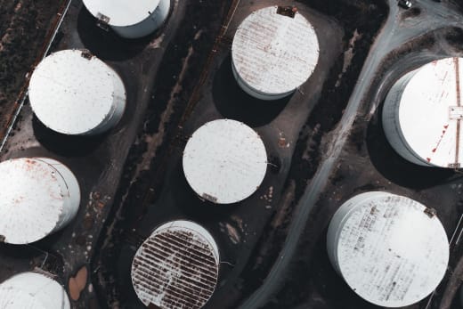 Drone shot showcasing large industrial storage tanks from above.