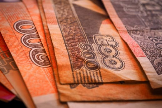 Macro shot of Cambodian Riel banknotes in a fanned arrangement displaying intricate designs and denominations.