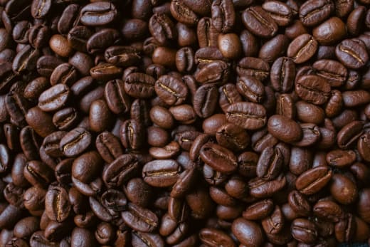 Closeup of aromatic roasted coffee beans showcasing rich textures and deep brown hues.