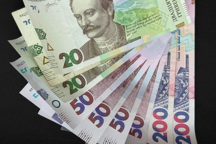 Fanned out Ukrainian Hryvnia banknotes featuring various denominations and vivid colors.