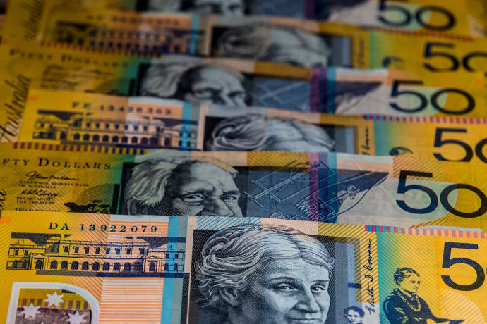 Close-up view of Australian $50 bills arranged in a pattern. Vibrant colors and detailed imagery highlight currency features.
