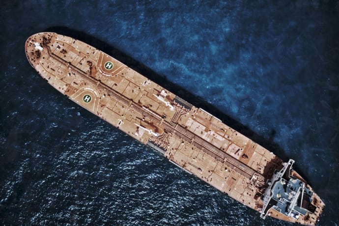 Drone shot of large tanker ship with helipads in ocean waters.
