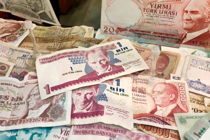 Turkish Lira banknotes of various denominations displayed, showcasing historical currency.