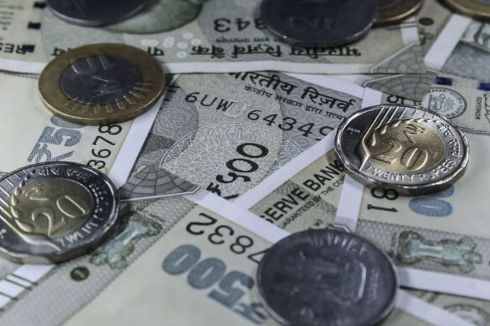 Detailed view of Indian rupee banknotes and coins, showcasing currency variety.