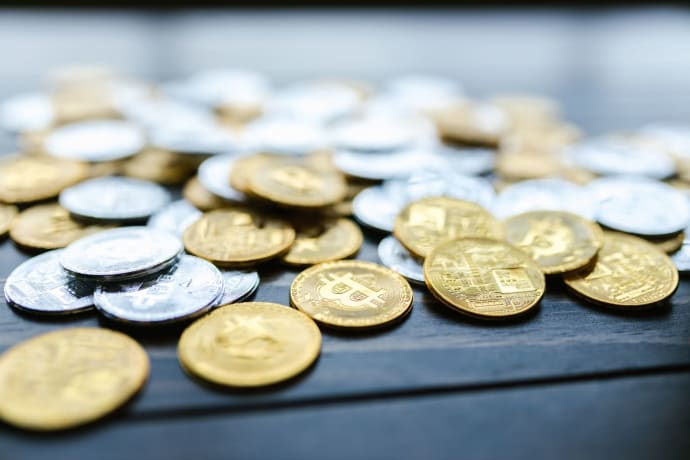 A detailed view of various cryptocurrency coins scattered on a wooden surface.