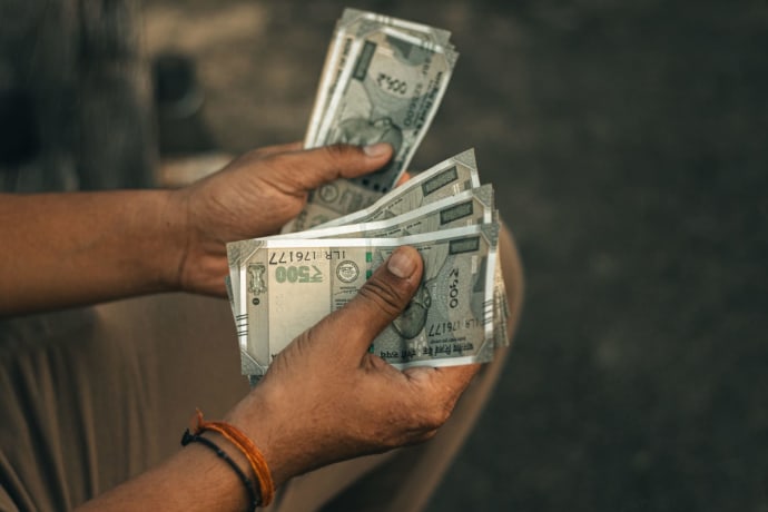Close-up of hands holding multiple 500 Indian Rupee notes, representing wealth and financial transactions.