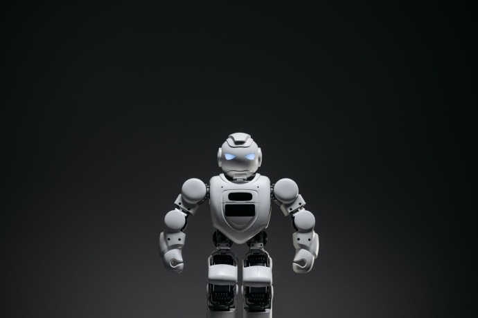 Close-up of a white toy robot with glowing eyes in a studio setting.