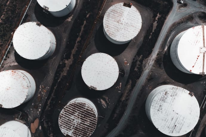 Drone shot showcasing large industrial storage tanks from above.