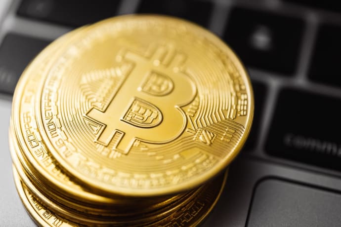 Close-up image of Bitcoin coins stacked on a laptop keyboard, symbolizing digital currency and blockchain technology.