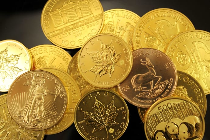 A detailed close-up of diverse gold bullion coins from different countries.