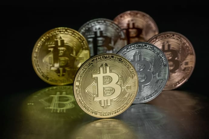 Close-up image of Bitcoin coins displayed on a reflective metallic surface, highlighting cryptocurrency concepts.
