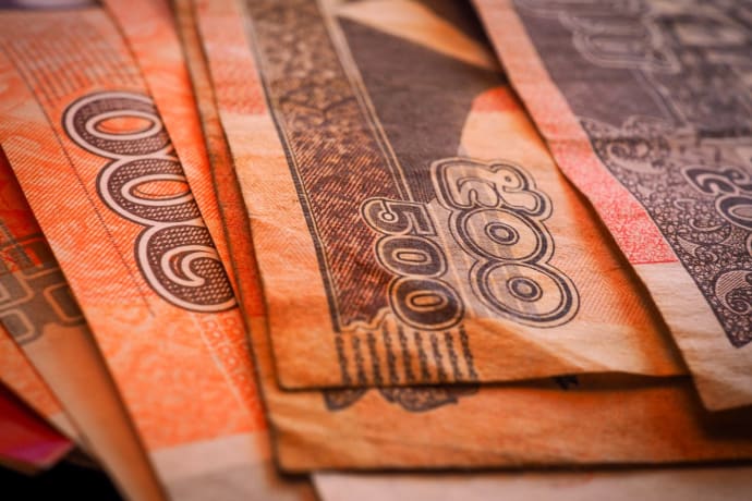 Macro shot of Cambodian Riel banknotes in a fanned arrangement displaying intricate designs and denominations.