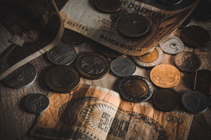 A close-up view of assorted vintage coins and banknotes on a table.