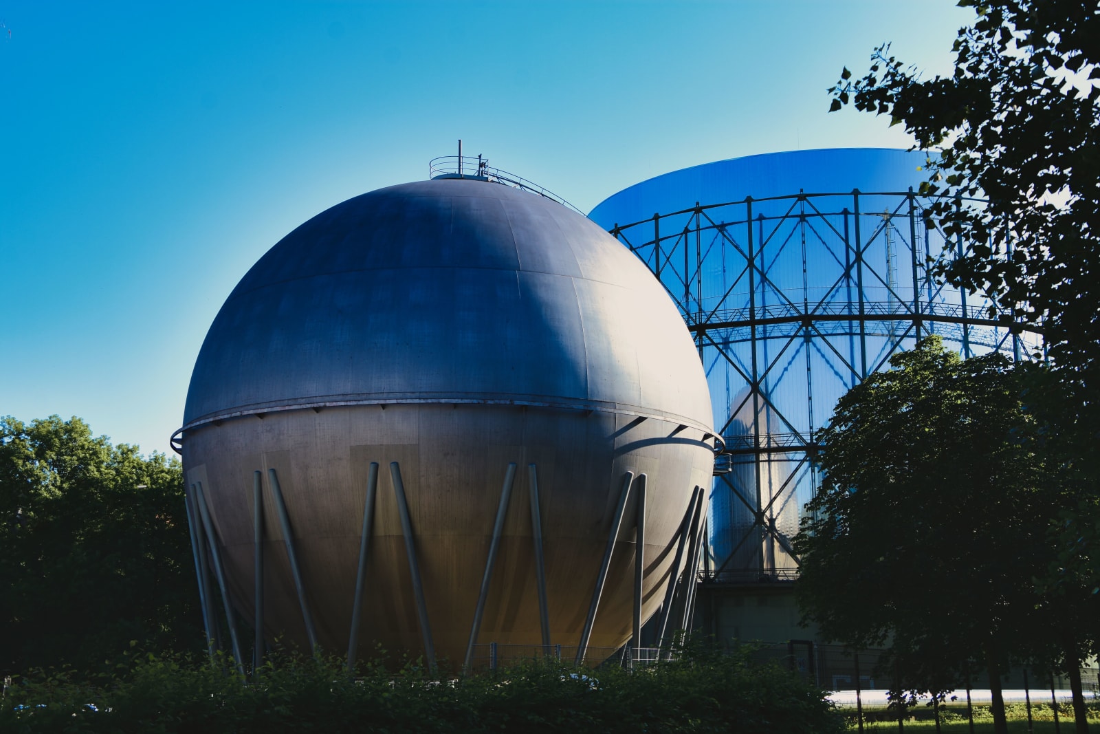 Gasometers in Pforzheim, Germany under a clear blue sky, showcasing industrial architecture.