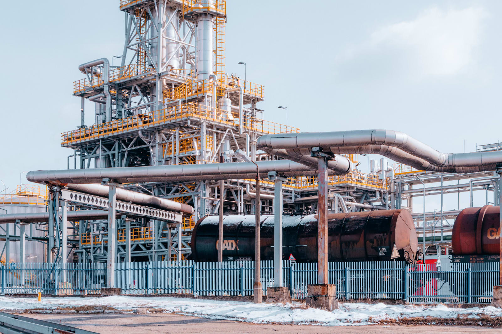 Oil refinery facility with tanker wagons in Trzebinia, Lesser Poland Voivodeship under a clear sky.