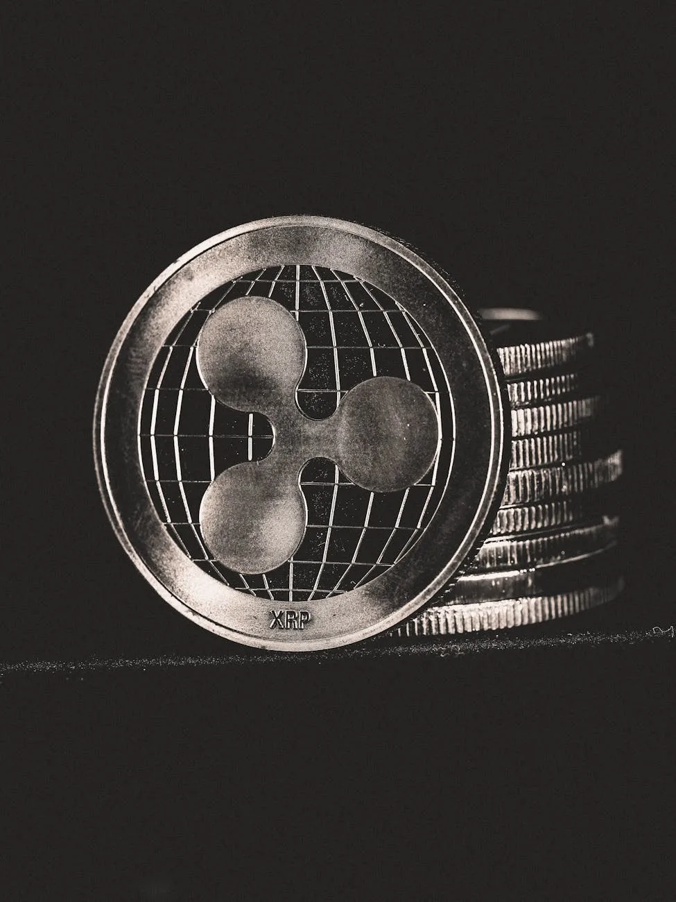 Monochrome image of Ripple coins stacked vertically, symbolizing digital currency.