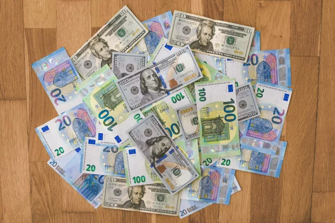 Aerial view of mixed Euro and US Dollar banknotes on a wooden floor, symbolizing global finance.