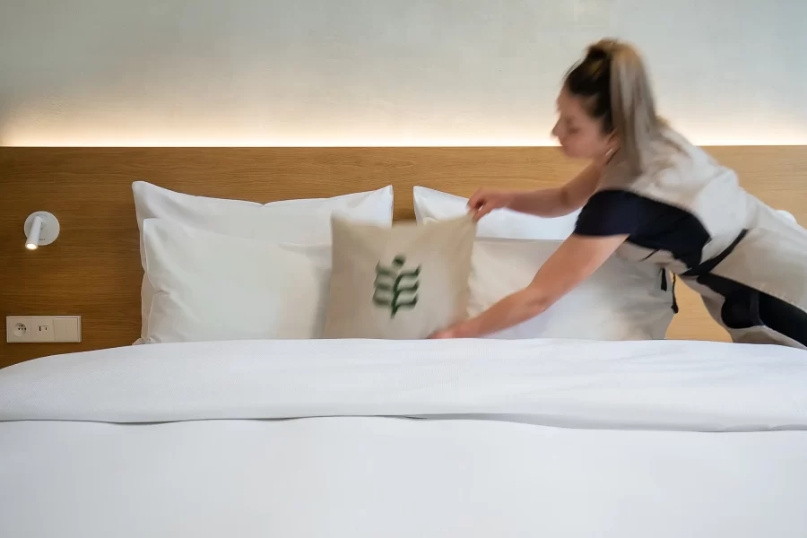 Lifestyle-Hotelfotografie der Bettvorbereitung durch den Housekeeping-Service im Hotel Botanique Prag